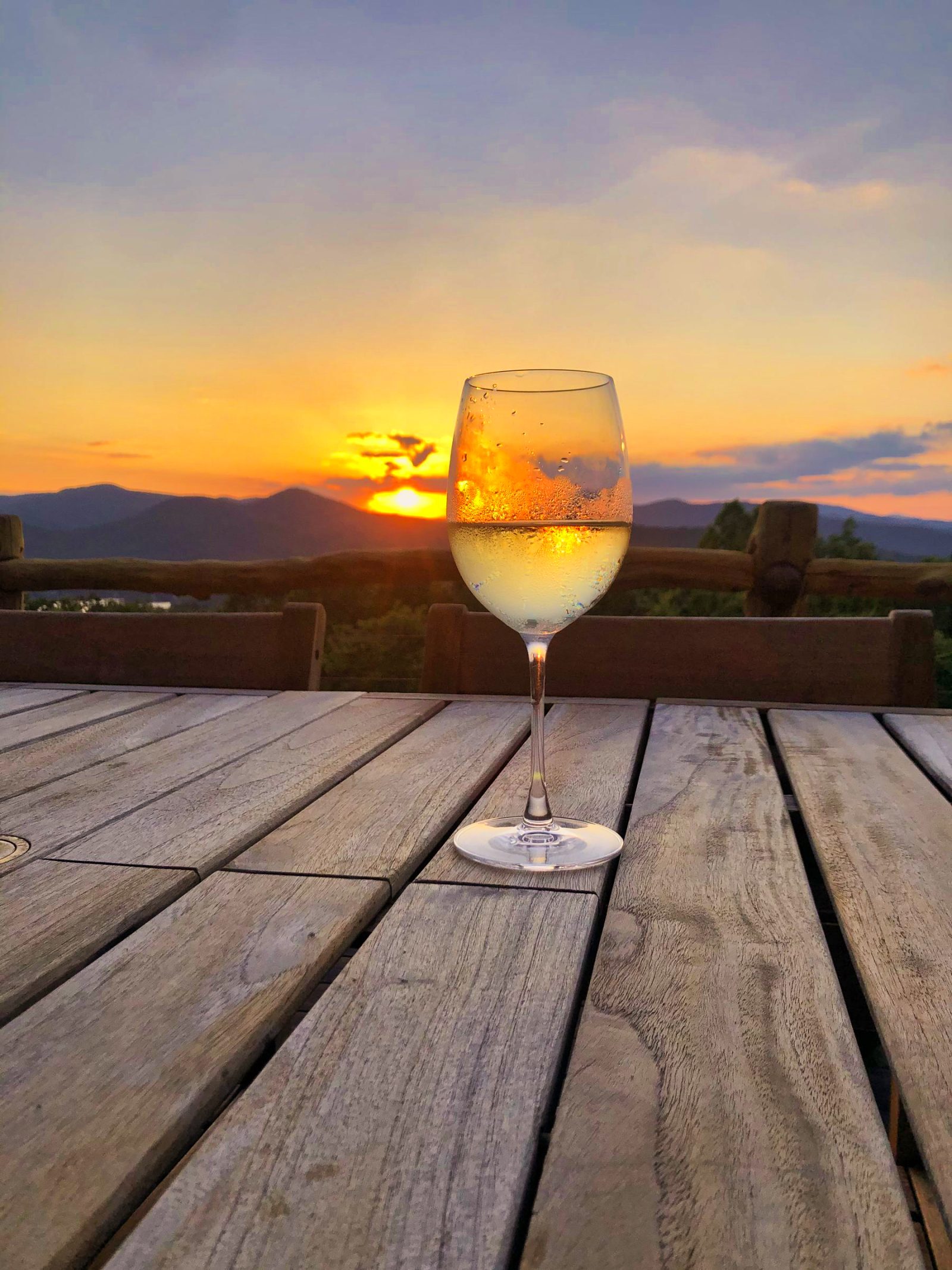 Wine glass at mountain sunset