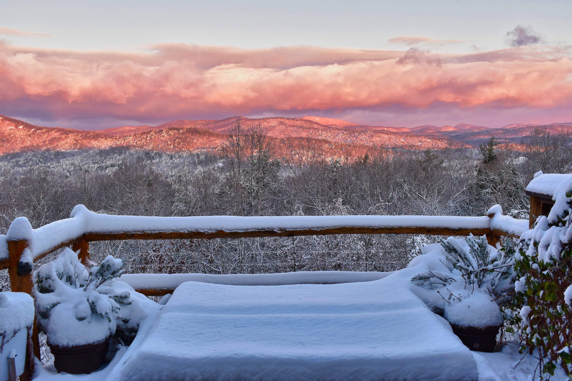 Snowy deck at mountain sunset — pink clouds over Blue Ridge