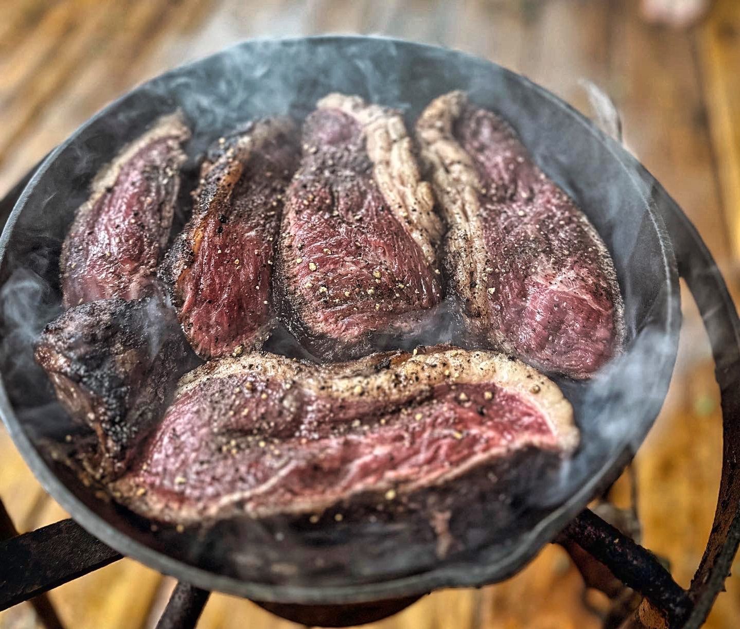 Piccanha steaks searing on a charcoal grill